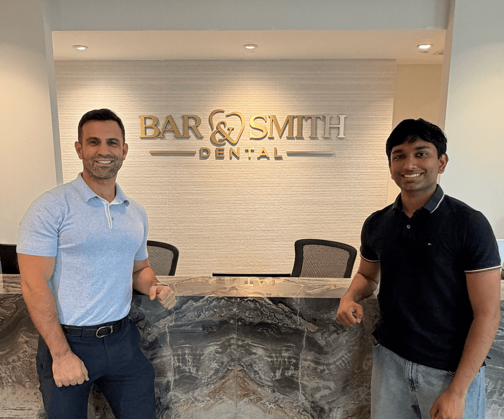 Two people at the Bar & Smith Family Dental reception desk